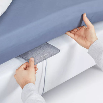 Withings Sleep Tracking Mat, a Bluetooth and Wi-Fi sleep monitor showing the mat placed on a bed for sleep analysis.