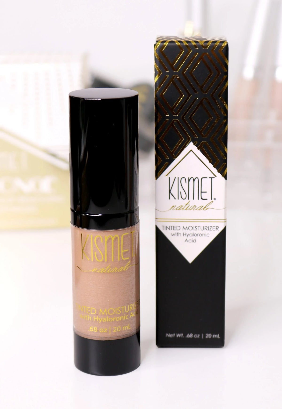 Kismet Natural Tinted Moisturizer with Hyaluronic Acid in a tinted tan shade, showing smooth, lightweight formula on the skin.