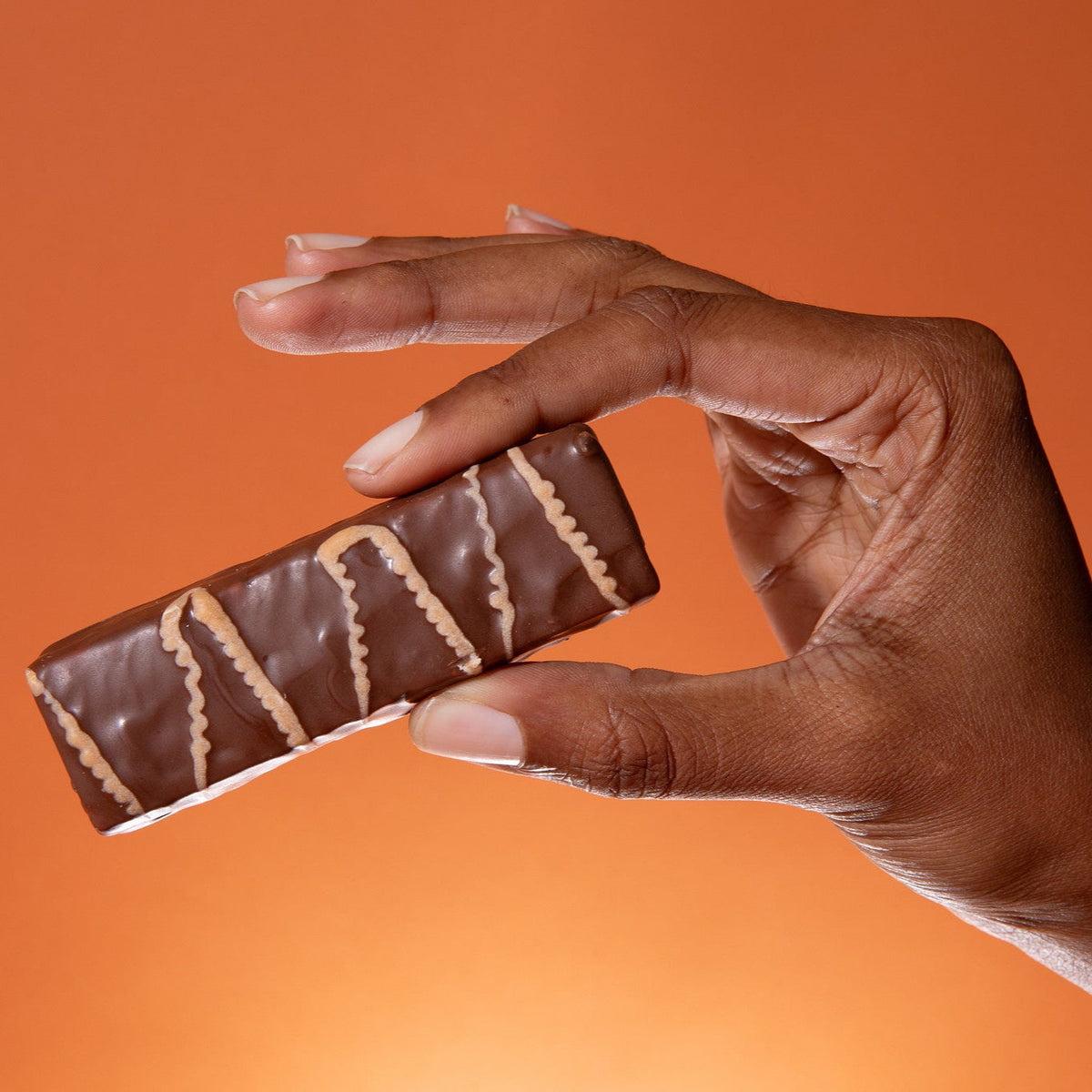 Biocare high protein chocolate caramel bar showing a chocolate-coated snack with caramel filling and branding on packaging.