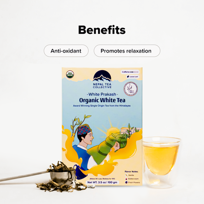 Organic White Prakash Nepal Tea in a clear glass cup, showcasing its pale, delicate brew with fresh tea leaves in the background.