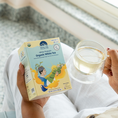 Organic White Prakash tea leaves from Nepal Tea, showcasing fresh, dried white tea buds and leaves in a natural setting.