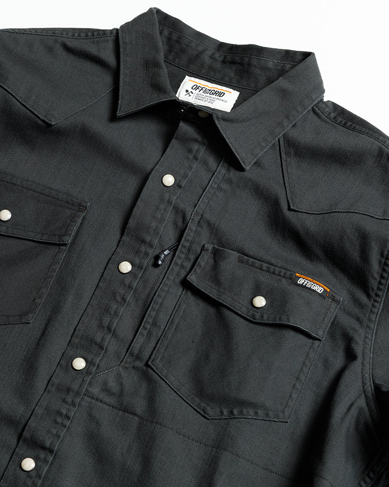 Off The Grid Surplus Earl Denim Shirt in vintage black, long sleeve woven denim shirt displayed on a hanger.