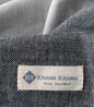 Black Krama Jeans made from traditional Krama fabric by Krama Krama, showing the detailed woven textile in a close-up view.
